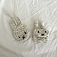 two crocheted rabbits on a white bed