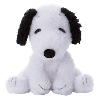 a white and black stuffed dog sitting on a black background
