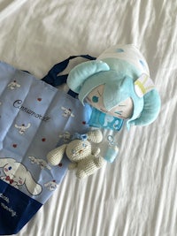 a stuffed animal and a tote bag on a bed