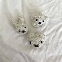 three crocheted stuffed animals on a white bed